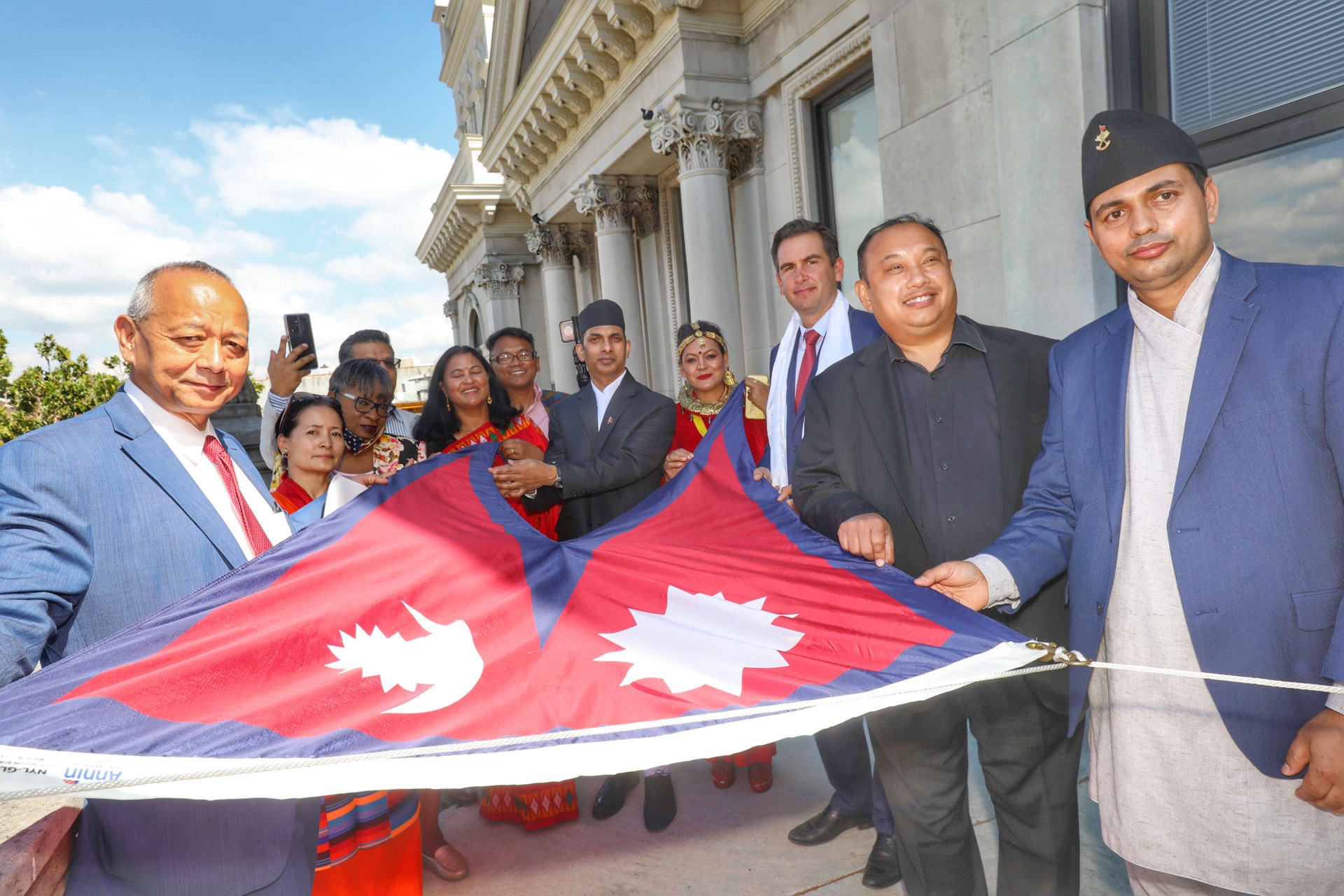 Several citizens are pictured holding the flag before it is raised The national flag of Nepal is a simplified combination of two single pennants. Its crimson red is the color of the rhododendron, the country's national flower. Red is also the sign of victory in war.