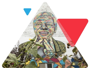 A colorful mural of a smiling person with hands near their face
